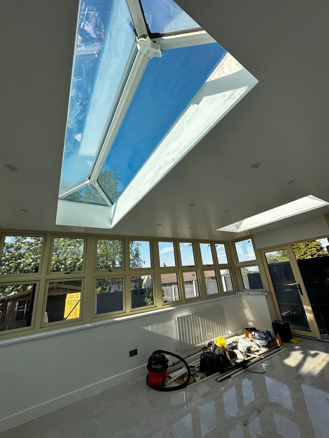 Bright rear house extension with glazed roof lantern, downlights and porcelain floor tiling by ERCO Home Improvements London