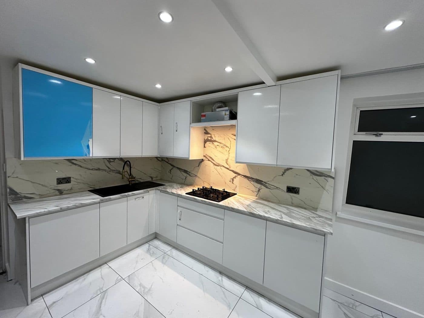 Modern handleless white gloss kitchen with marble worktop and splashback fitted in London by ERCO Home Improvements